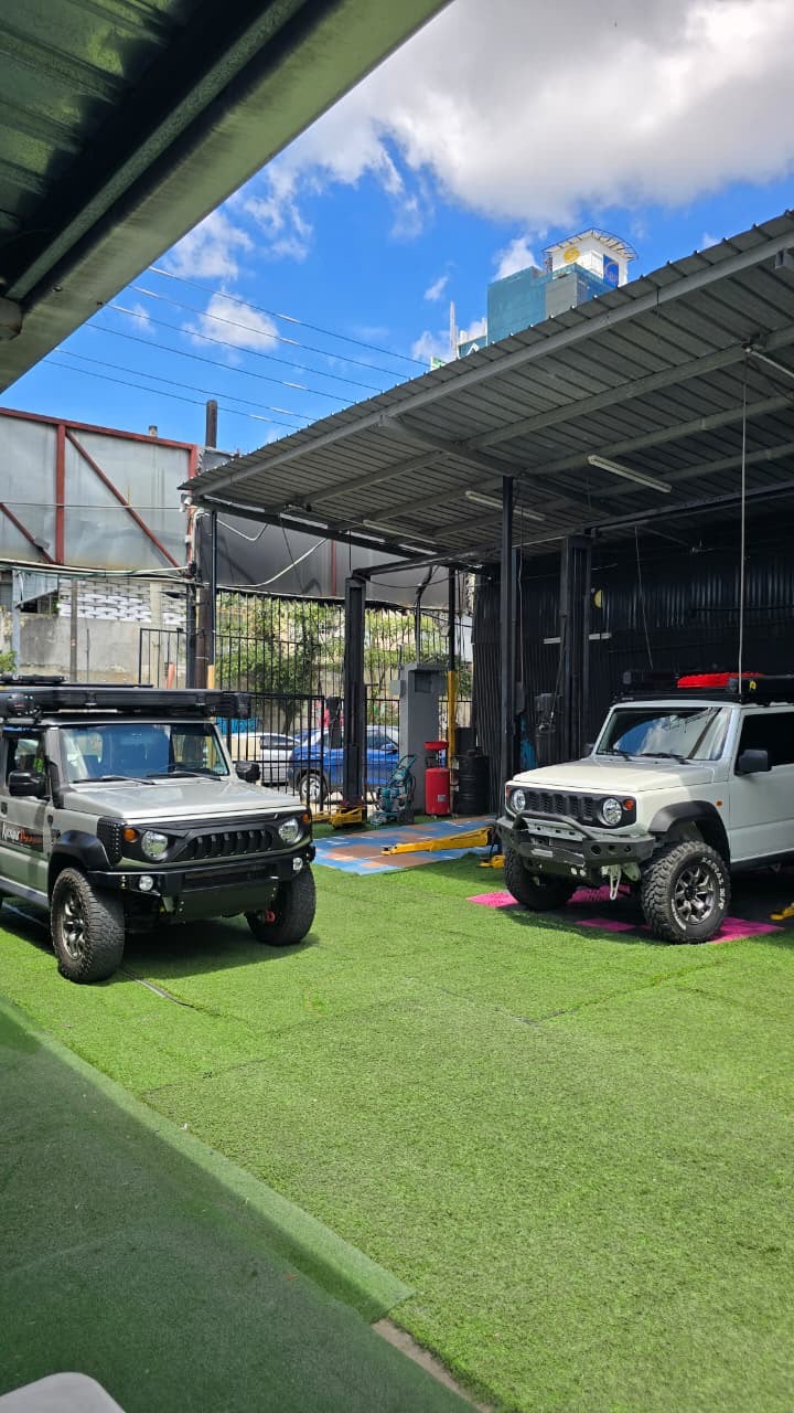 Entrada y área de trabajo de Grand Motor con dos vehículos y los elevadores al fondo